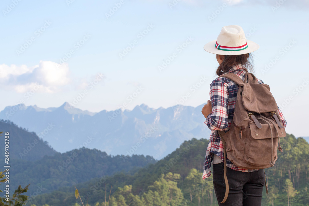 Young traveler woman with stylish backpack  looking forward at amazing mountains view. Enjoying nature, relax, pleasure.