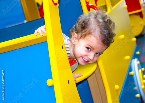 Adorable little 1-2 year old toddler boy on the playground, child wearing jersey and jeans