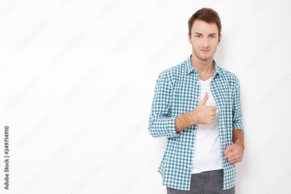 Portrait of young happy cheerful man showing thumbs up isolated on white. Portrait of young happy cheerful man showing thumbs up isolated on white.