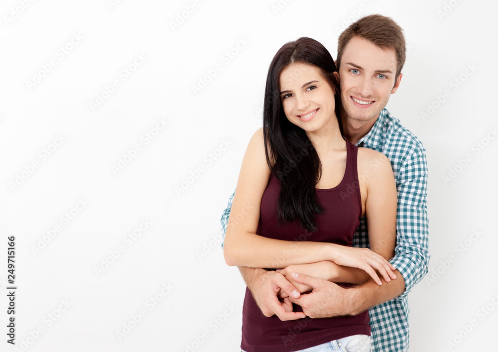 Happy couple embracing and looking camera on white background Happy couple embracing and looking camera on white background