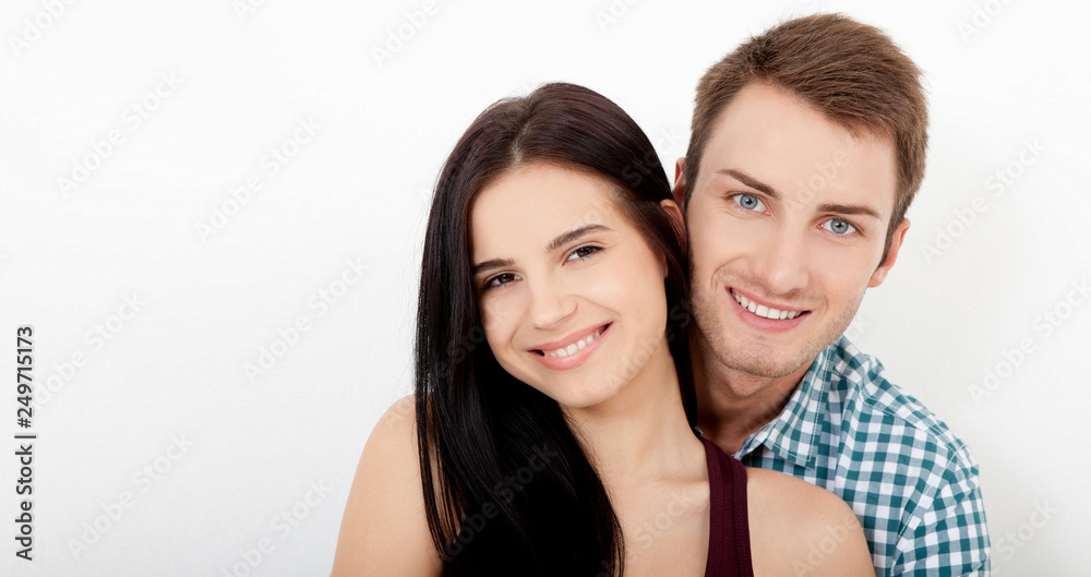 Happy couple embracing and looking camera on white background Happy couple embracing and looking camera on white background