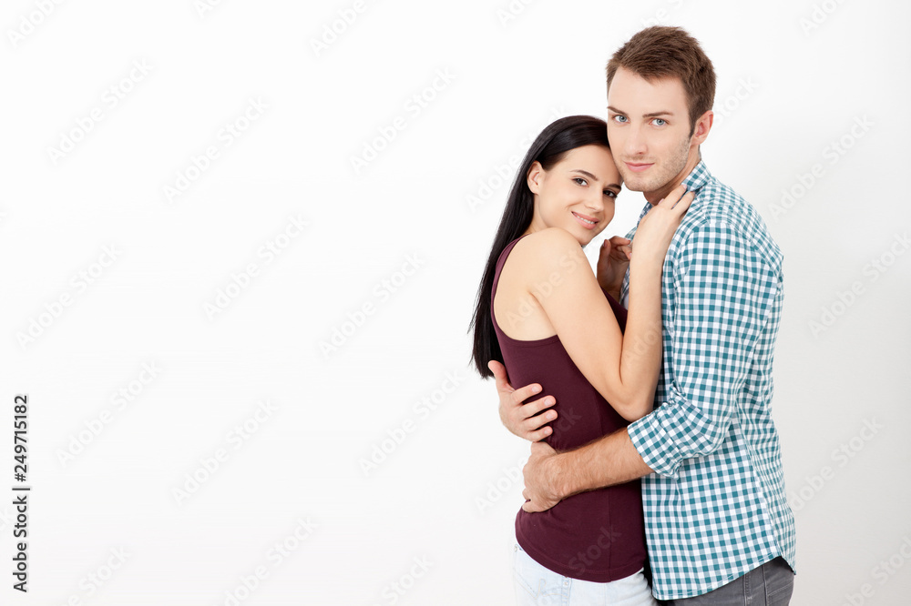 Happy couple embracing and looking camera on white background Happy couple embracing and looking camera on white background