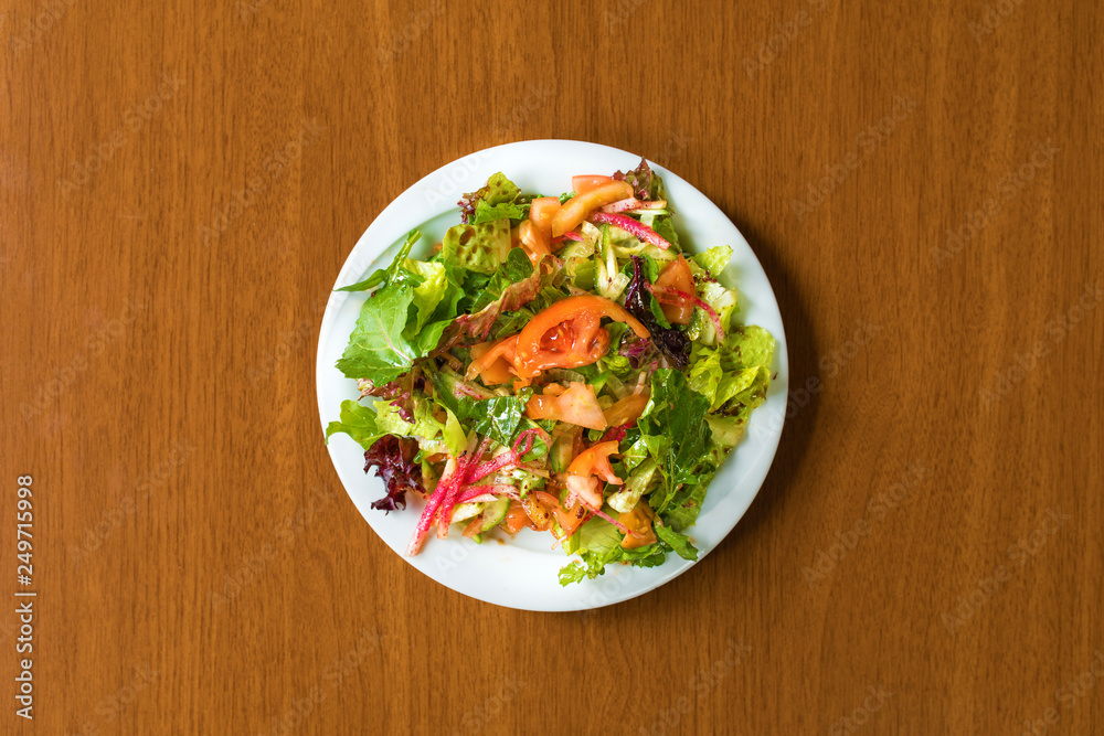 Traditional Turkish or Greek Salad in plate on wooden table Traditional Turkish or Greek Salad in plate on wooden table