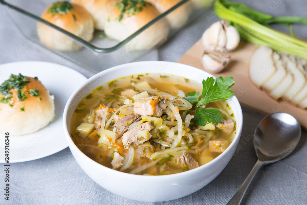 Shchi (cabbage soup) with buns (pampushki), fat and garlic. Traditional Russian and Ukrainian soup. Selective focus, close-up. Shchi (cabbage soup) with buns (pampushki), fat and garlic. Traditional Russian and Ukrainian soup. Selective focus, close-up.