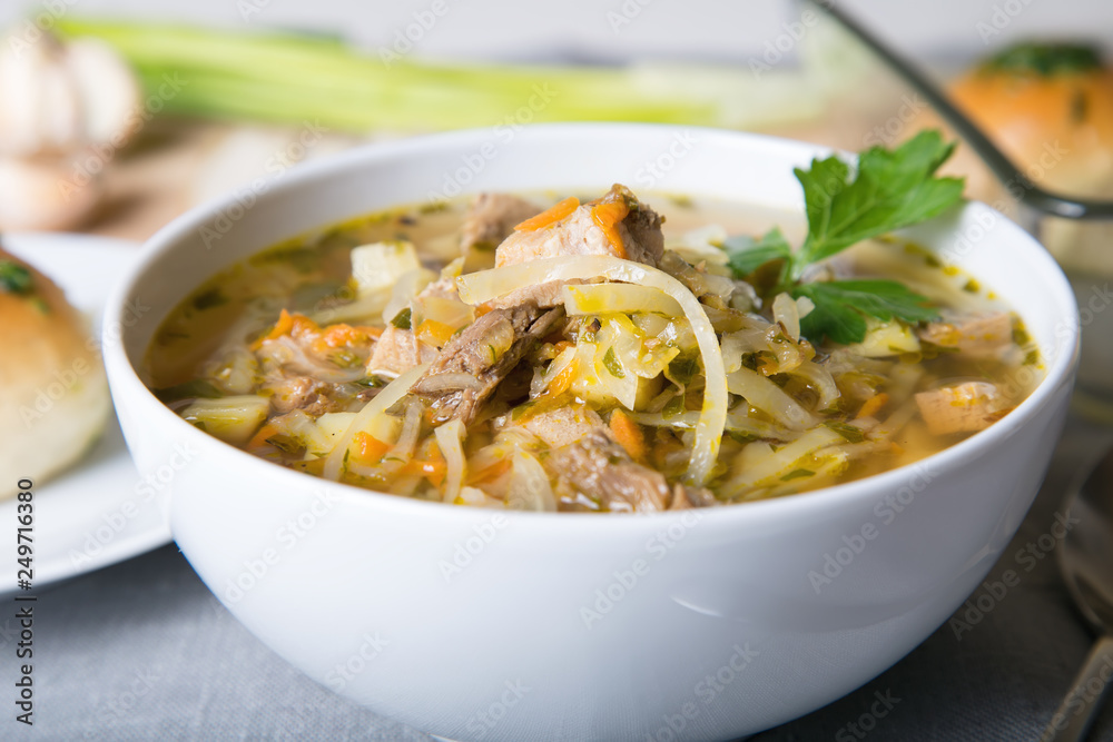 Shchi (cabbage soup) with buns (pampushki), fat and garlic. Traditional Russian and Ukrainian soup. Selective focus, close-up. Shchi (cabbage soup) with buns (pampushki), fat and garlic. Traditional Russian and Ukrainian soup. Selective focus, close-up.