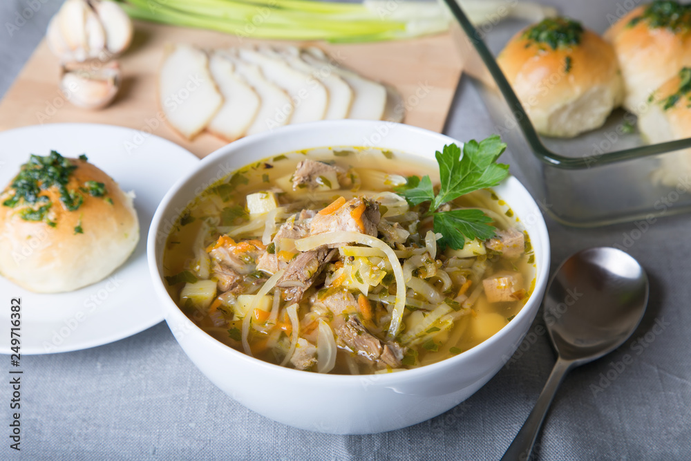 Shchi (cabbage soup) with buns (pampushki), fat and garlic. Traditional Russian and Ukrainian soup. Selective focus, close-up.