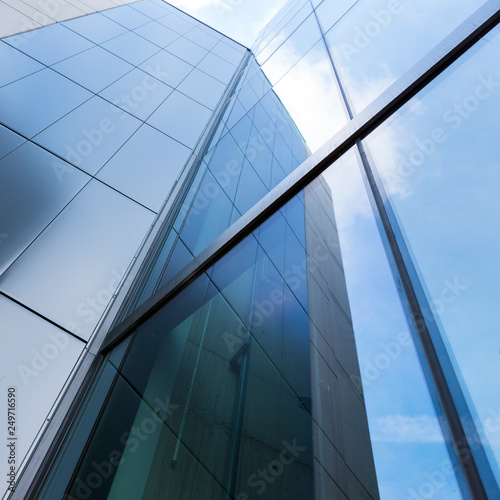 detail of modern office building with glass and steel reflecting blue sky