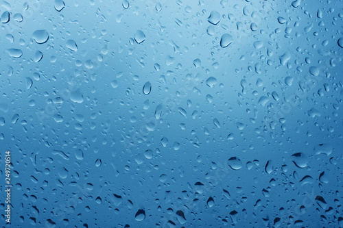 Water drops on glass on blue sky background