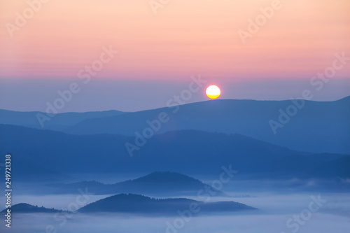 quiet sunrise over the misty mountain valley