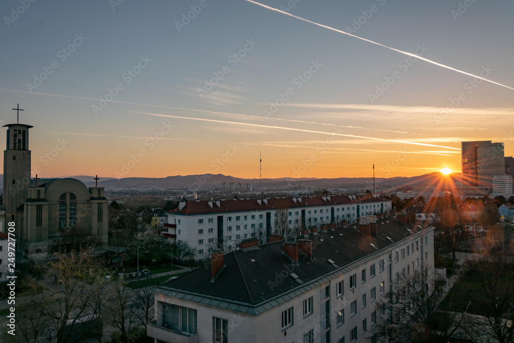 Sunset in Vienna with a church and an office building in front