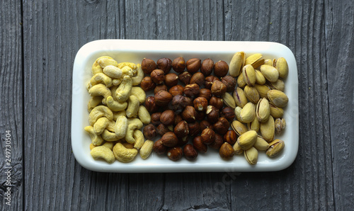 Assortment of nuts on a dark wooden table. View from above