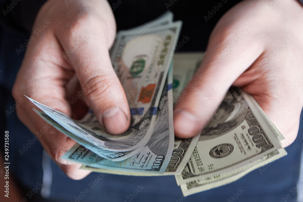 Man holdin money. Concept of savings, salary, payment and funds. Man counts cash bills.. Man holdin money. Concept of savings, salary, payment and funds. Man counts cash bills..