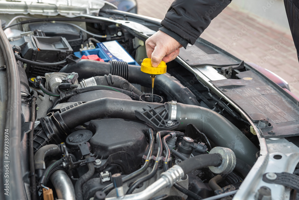 custom made wallpaper toronto digitalMan checking oil level in car engine.