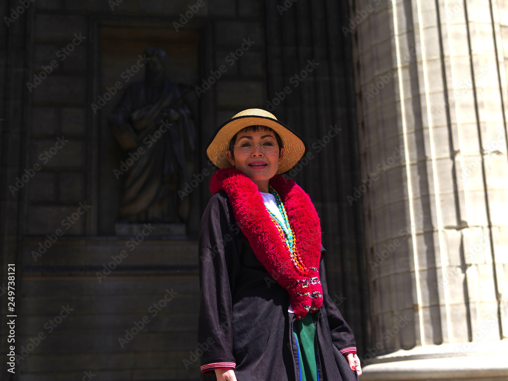 Femme en manteau noir et écharpe rouge devant l'église de la Madeleine à Paris