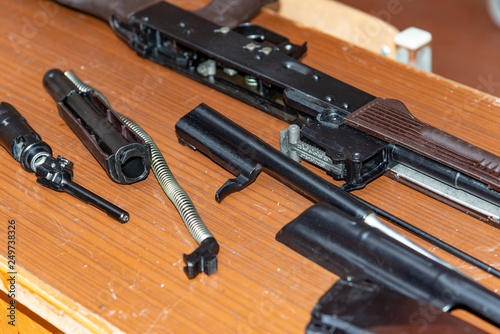 Kalashnikov assault rifle disassembled on a table at military exercises.