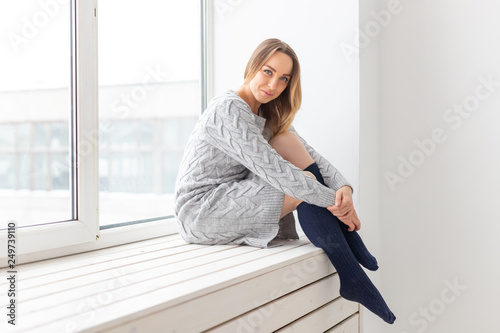 People and fashion concept - Gorgeous romantic woman in wool dress sitting on the window sill Free Download People and fashion concept - Gorgeous romantic woman in wool dress sitting on the window sill - GFXLoad