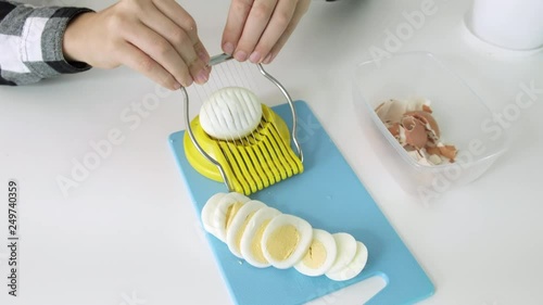 Cutting eggs of egg slicer on board close-up