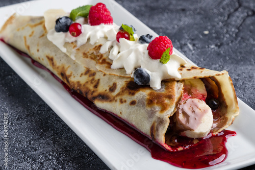 european pancakes, sweet crepe with topping on white long plate