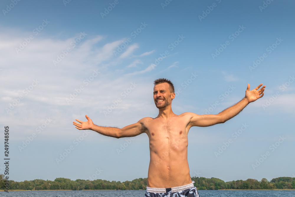 Happy young man with open arms enjoying summer freedom Happy young man with open arms enjoying summer freedom