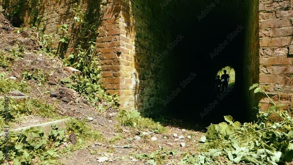 adventurous kids with flashlights coming out of a tunel
