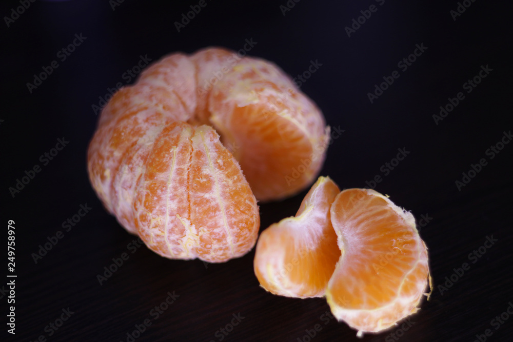 ripe tangerine slices on a dark background in isolation ripe tangerine slices on a dark background in isolation