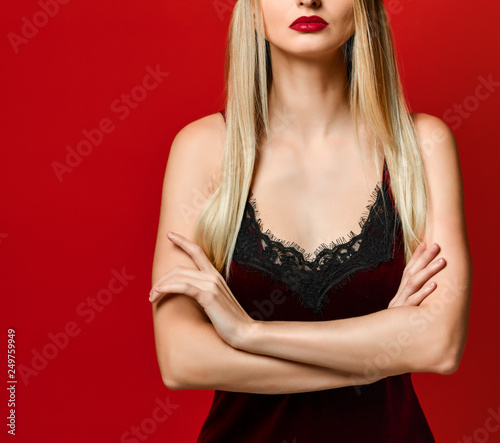 Indoor shot of serious strict young female dressed velvet dress keeping arms folded photo