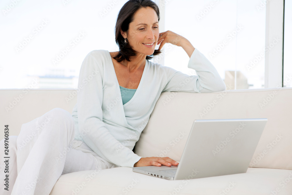 beautiful middle aged woman using computer at home