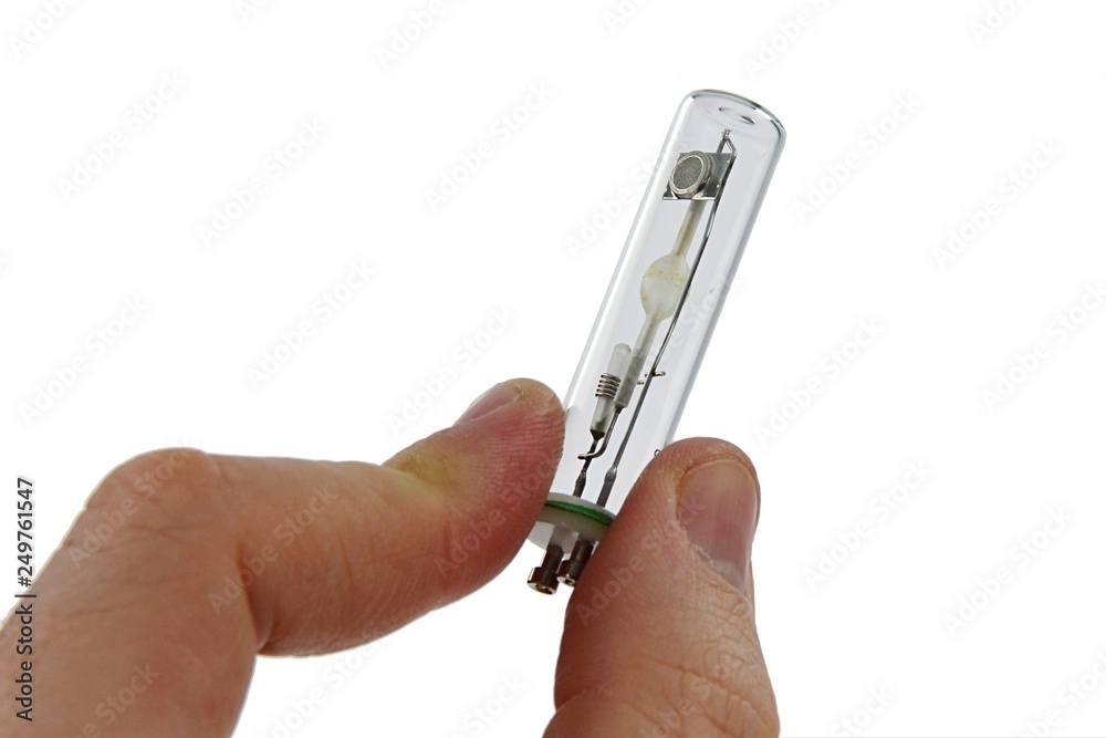 Small metal halide light bulb with GU10 10 mm mount held in right index finger and thumb, white background Small metal halide light bulb with GU10 10 mm mount held in right index finger and thumb, white background
