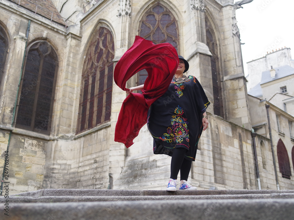 Femme agitant une étoffe de soie rouge devant l'église Saint Gervais à Paris Femme agitant une étoffe de soie rouge devant l'église Saint Gervais à Paris