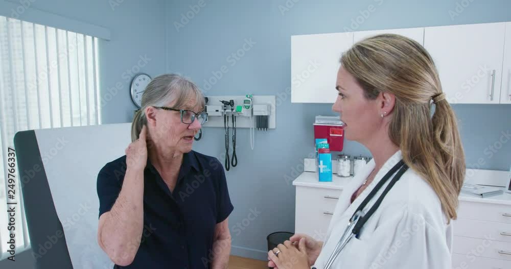 Female doctor talking to senior patient about neck problems in medical exam room. Older woman making regular visit to her primary care provider at her hospital. Slow motion 4k Female doctor talking to senior patient about neck problems in medical exam room. Older woman making regular visit to her primary care provider at her hospital. Slow motion 4k