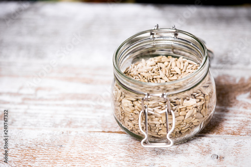 Shelled sunflower seeds in a jar on a wooden background. Healthy vegan food