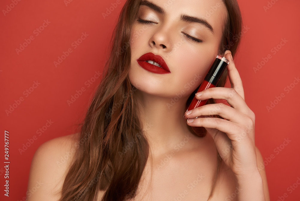 Close up portrait of attractive girl touching her face with bright lipstick