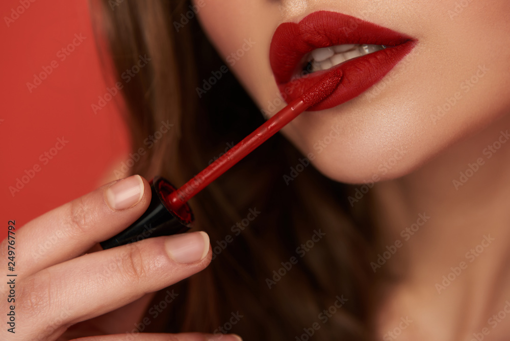 Cropped photo of woman with bright lipstick isolated on red background Cropped photo of woman with bright lipstick isolated on red background