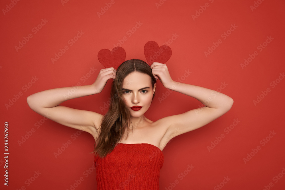Young pretty girl imitating bunny ears by Valentines cards on red background Young pretty girl imitating bunny ears by Valentines cards on red background