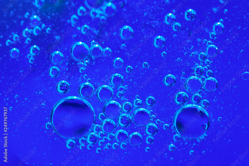Bubbles of oxygen under water. Blue toned water structure. Selective focus.