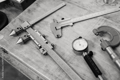 Metal measuring instruments on a wooden table. Product quality control.