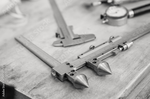 Metal measuring instruments on a wooden table. Product quality control.