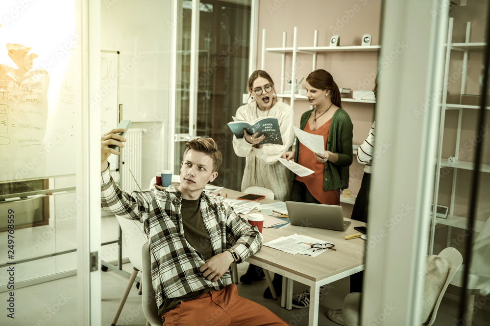 Obraz premium Blonde student making selfie with his group mates having discussion