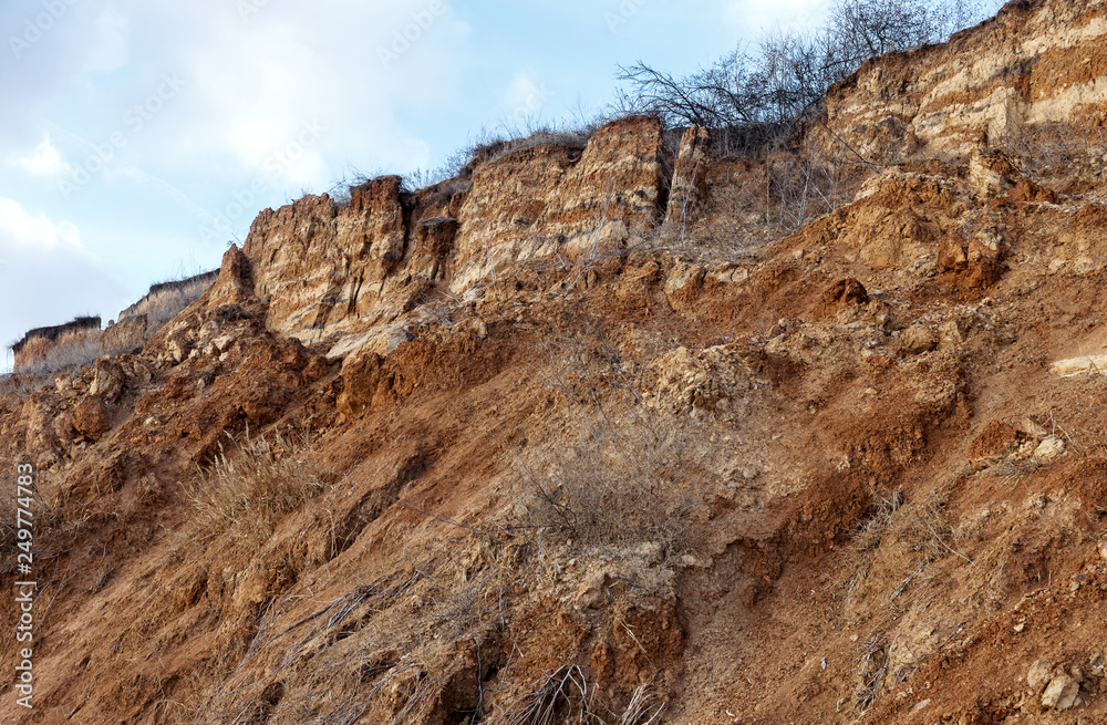 Landslide zone on Black Sea coast. Rock of sea rock shell. Zone of natural disasters during rainy season. Large masses of earth slip along slope of hill, destroy houses. Landslide - threat to life Landslide zone on Black Sea coast. Rock of sea rock shell. Zone of natural disasters during rainy season. Large masses of earth slip along slope of hill, destroy houses. Landslide - threat to life