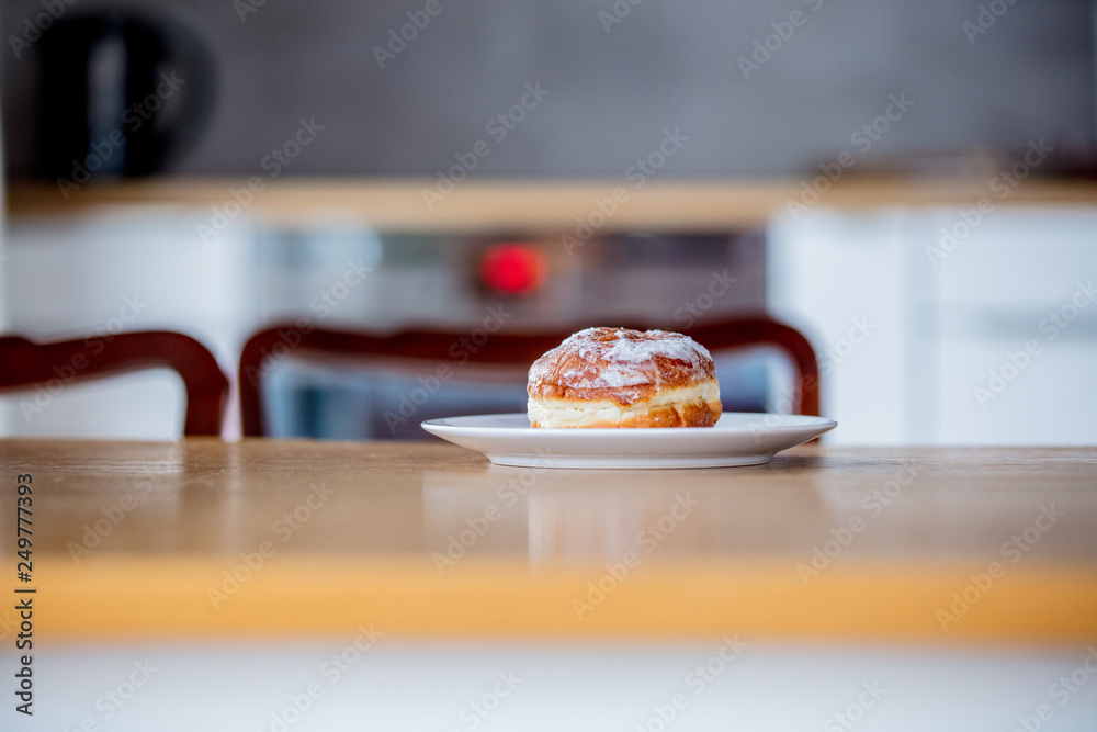 donut on white plate on wooden table at kitchen