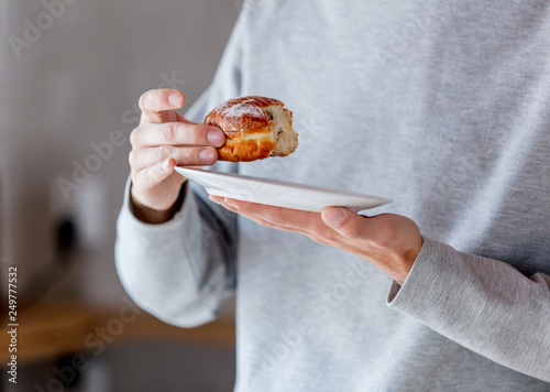 Man eating donut on breakfast at kitchen