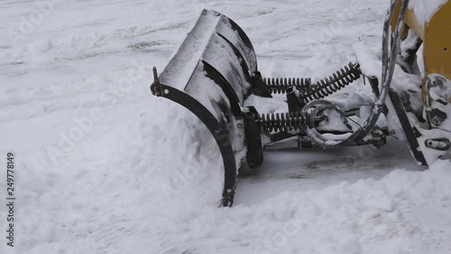 Slow motion snow plow at work. Clearing driveway and making a snowpile. Snow falling. Winter in Canada.