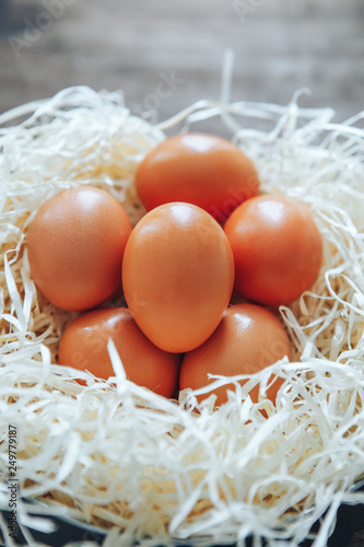 Wood wool eggs, dark wooden background.