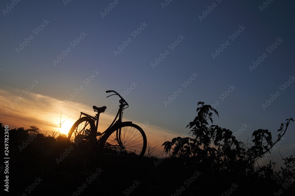 Fototapeta premium Silhouette of old bike with sunset light