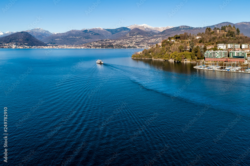 Landscape of Lake Maggiore with ferry that crosses the lake in LavenoMombello, province of Varese, Italy