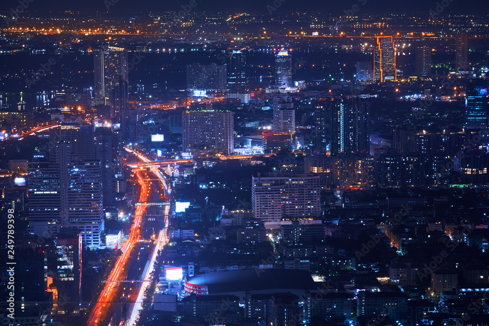 night top view cityscape from highest rooftop building view with light tail traffic