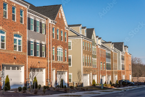 Typical American town house, town home neighborhood with colorful real estate houses at a new construction East Coast Maryland location with blue sky