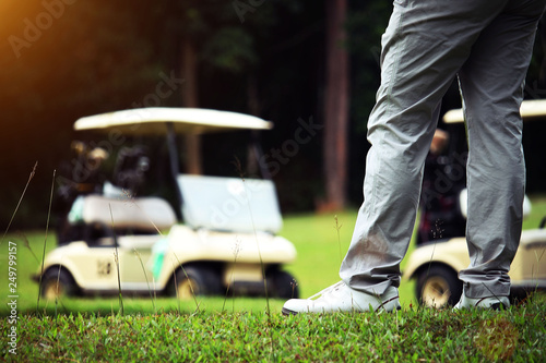 Golfer and golfcar in beautiful golf course in the evening golf course with sunshine photo