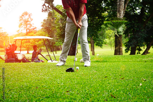 Golfer playing golf beside the golfcar in beautiful golf course in the evening golf course with sunshine in thailand