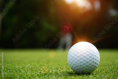 Foto Blurred golf ball on green in beautiful golf course with sunset